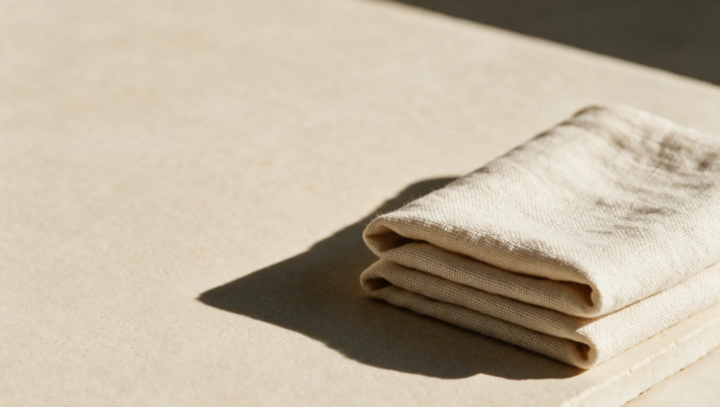 Folded linen on a pale surface — AI-generated editorial imagery